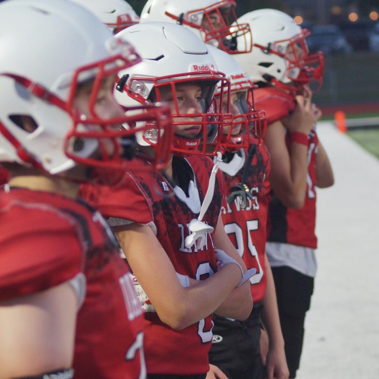 Junior Bulldogs football players focused together on the sideline