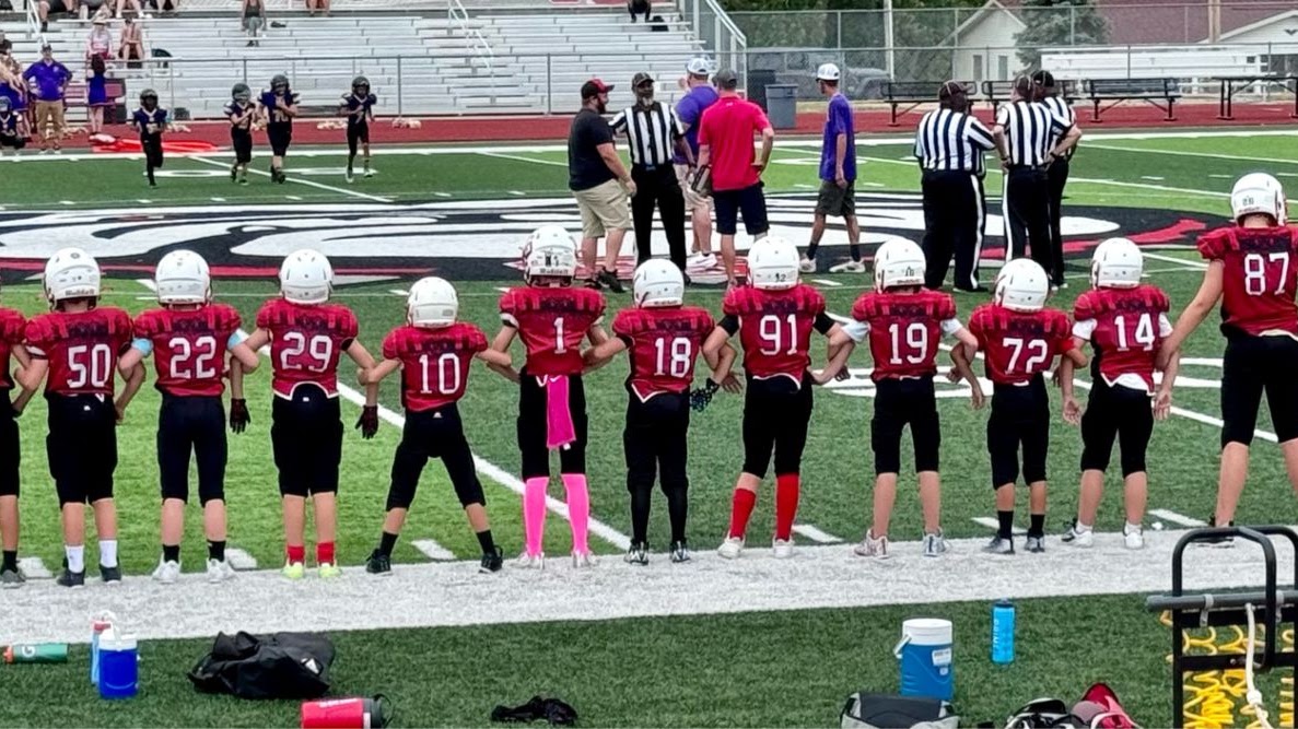 Junior Bulldogs football players standing together along the sideline